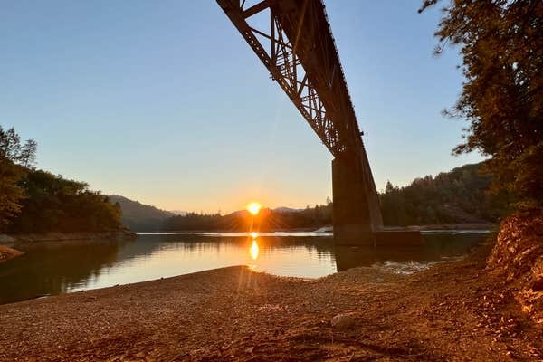 Sunset under the railroad trestle at the Lower Salt Creek shoreline, sun low over the water