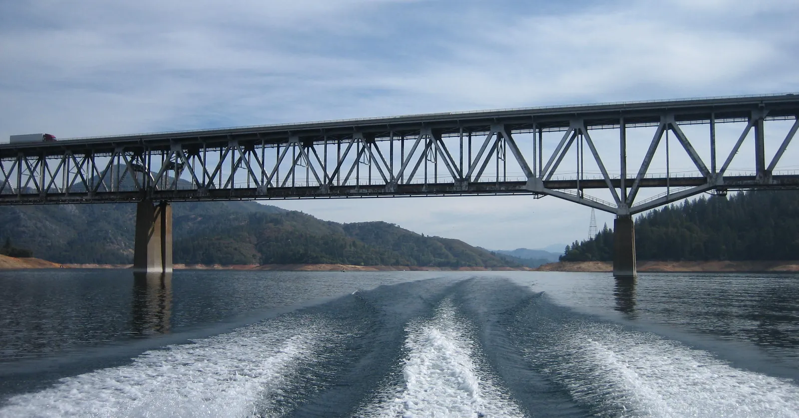 Boat wake heading under the Pit River Bridge at Bridge Bay, where I-5 crosses Shasta Lake