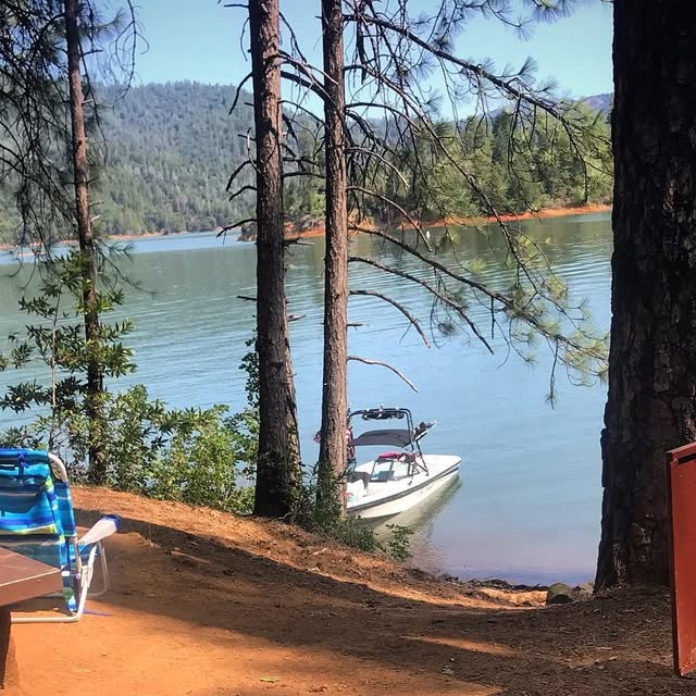 A ski boat beached below the pines at Greens Creek boat-in camp on Shasta Lake